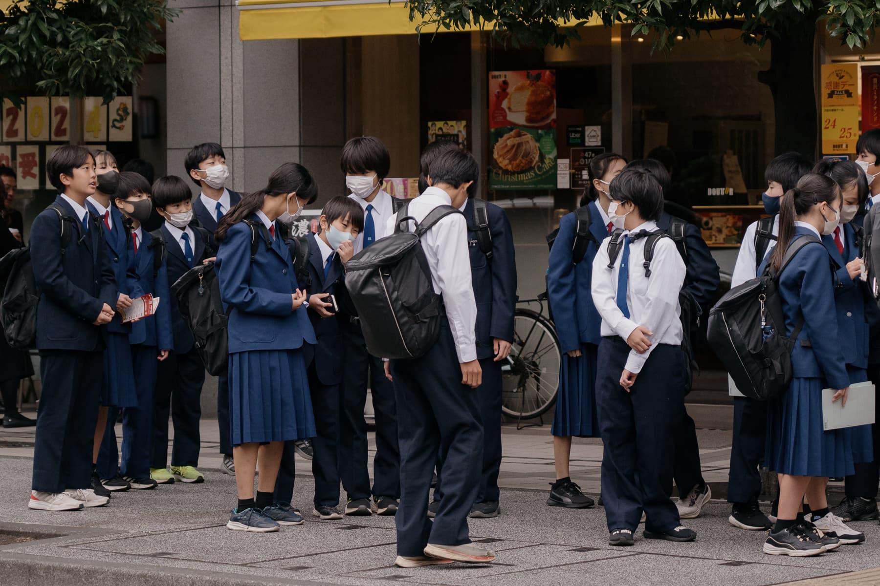 Students interacting with each other on a school trip in Yokohama. The pressures of group dynamics are felt from a young age. According to a 2021 report by the Cabinet Office, the top three challenges for youth in school were bullying, group participation, and relationships with friends.